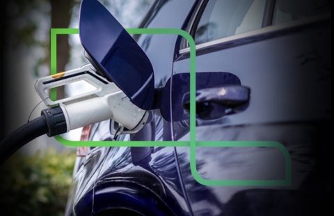 Imagem traz um carregador elétrico carregando um carro na cor azul. O P da marca estapar está envolvido nesta imagem.
