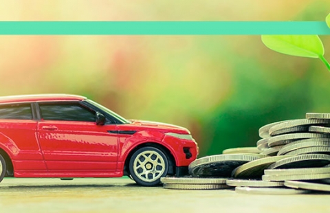 Na imagem um carro está próximo a uma pilha de moedas e a um ramo de folhas, representando a economia no IPVA e a sustentabilidade do veículo elétrico